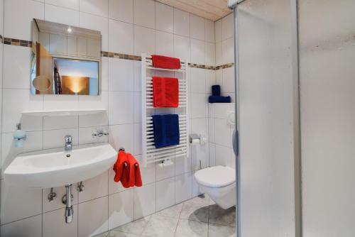 a white bathroom with a sink and a toilet at Haus Zitt in Grän