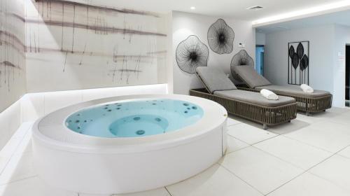 a bathroom with a tub in the middle of a room at Apartments Park Plava Laguna in Poreč