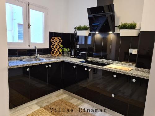 kuchnia z czarnymi szafkami i zlewem w obiekcie Adeje Penthouse by Villas Rinamar w Adeje