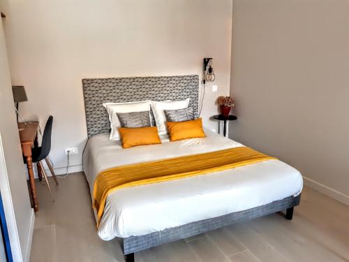 a bedroom with a large bed with orange pillows at 10 Côté Cour in Chaux