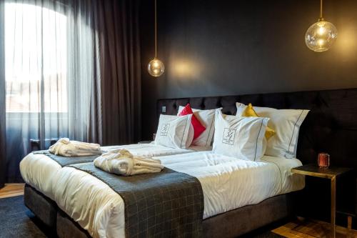 a bedroom with a large bed with towels on it at 34 GuestHouse in Setúbal