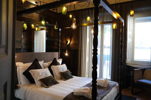 a bedroom with a canopy bed with white sheets and pillows at 34 GuestHouse in Setúbal