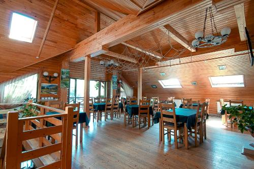 comedor con mesas, sillas y paredes de madera en Laguna en Slavske