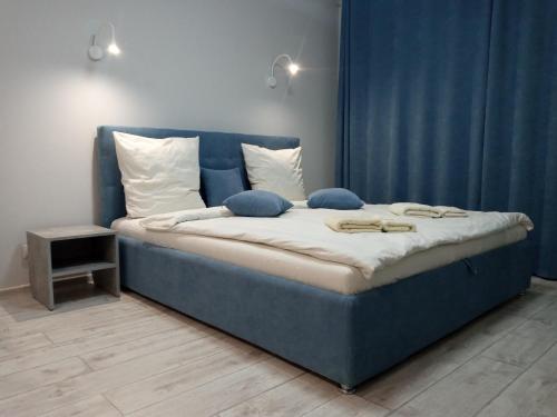 ein blaues Bett mit Kissen darauf in einem Zimmer in der Unterkunft Квартира в центре на Другетов in Uschhorod