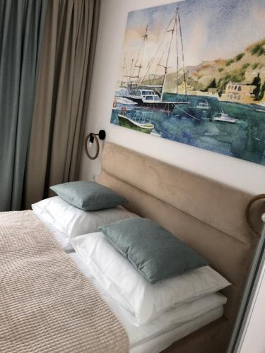 a bedroom with two pillows and a painting on the wall at Nadmorskie Tarasy Apartament 312 in Kołobrzeg