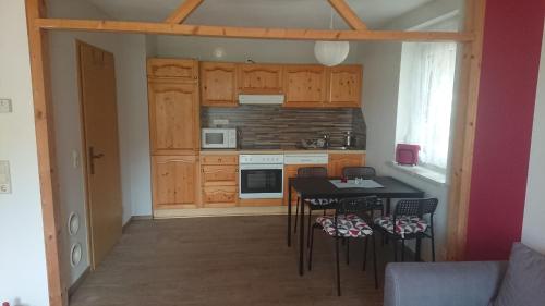 a kitchen with a table and chairs in a room at FeWo Erika in Lengenfeld