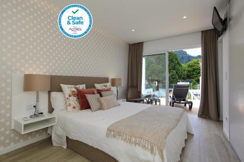 a bedroom with a large bed and a large window at Casa Nostra in Furnas