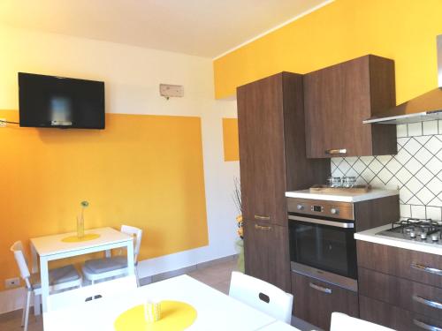 une cuisine avec des murs jaunes, une table et des chaises dans l'établissement The Yellow House, à Fiumicino