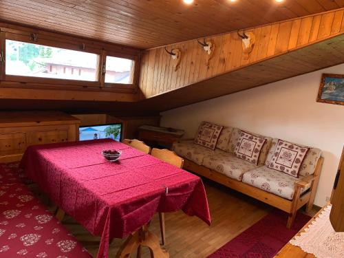 a dining room with a table and a couch at Attico Vista Tofane in Cortina dʼAmpezzo