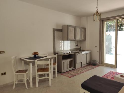 eine Küche mit einem Tisch und Stühlen sowie einem Tisch und Schränken in der Unterkunft il Faro di Zancle, la Porta della Sicilia in Messina