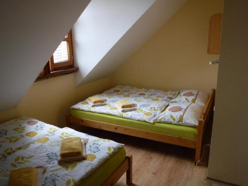 a bedroom with two beds in a attic at Farma Zahradnice in Olbramovice Ves