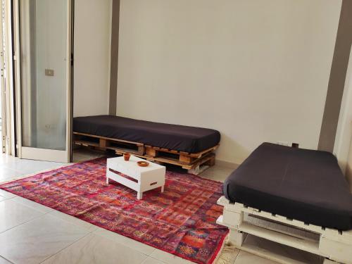 a bedroom with two beds and a rug at il Faro di Zancle, la Porta della Sicilia in Messina