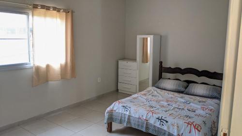 1 dormitorio con cama y ventana en Residência Schneider RC, en Vila Velha