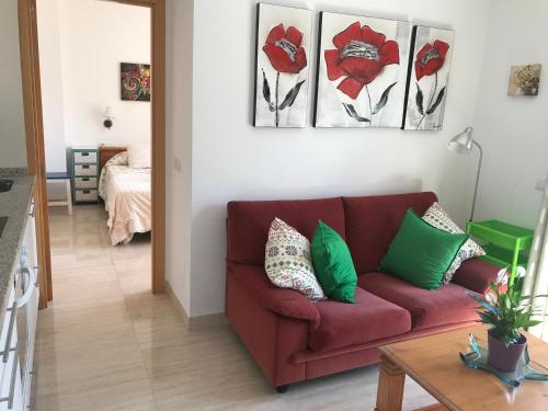 a living room with a red couch with green pillows at PLAZA DE ESPAÑA 1 DORMITORIO in Nerja