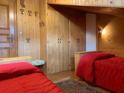 two beds in a room with wood paneling at Attico Vista Tofane in Cortina dʼAmpezzo