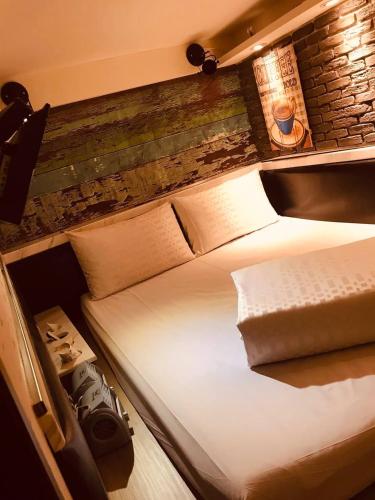 Bett in einem Zimmer mit Ziegelwand in der Unterkunft Kenting My Home in Kenting