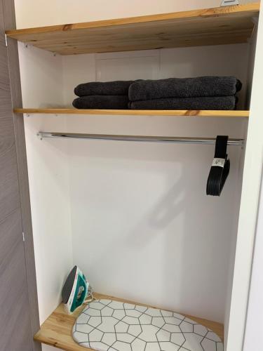 a small bathroom with wooden shelves and towels at Maya New Guest House -Panoramic Sea&CityCentre View, Haifa in Haifa