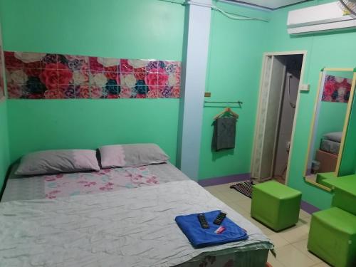 1 dormitorio con cama y espejo en กอล์ฟ​&กิ๊ฟ​โฮม, en Phitsanulok