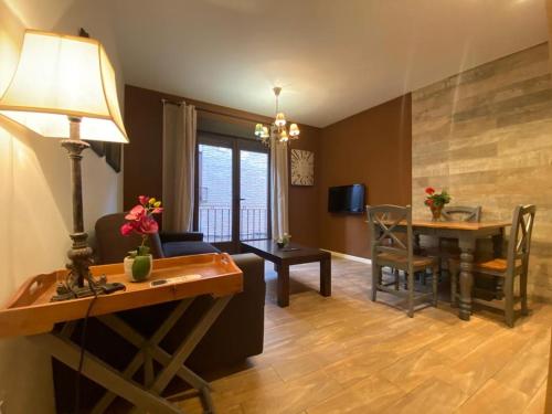 sala de estar con mesa y comedor en Alda Apartamentos Muralla de Toledo, en Toledo