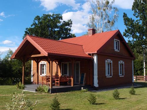 una pequeña casa con techo rojo en Jałówka - odpocznij na Podlasiu, en Jałówka