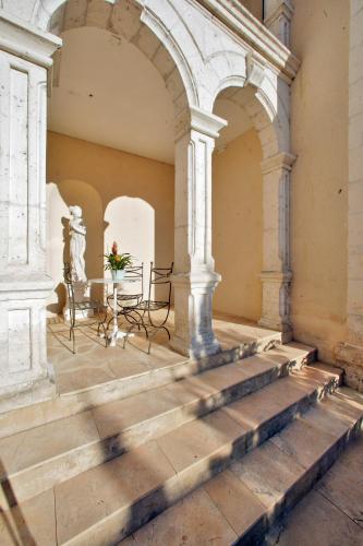 a patio in an old building with a table and chairs at Hotel Le Renoir in Sarlat-la-Canéda