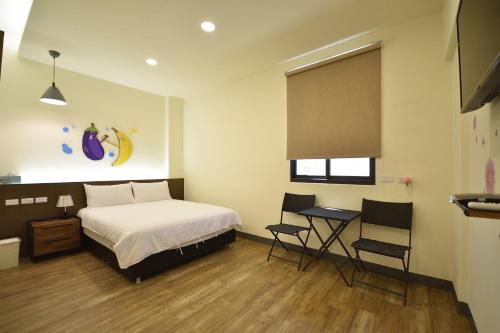台东香茄民宿的一间卧室，配有一张床、一张桌子和几把椅子