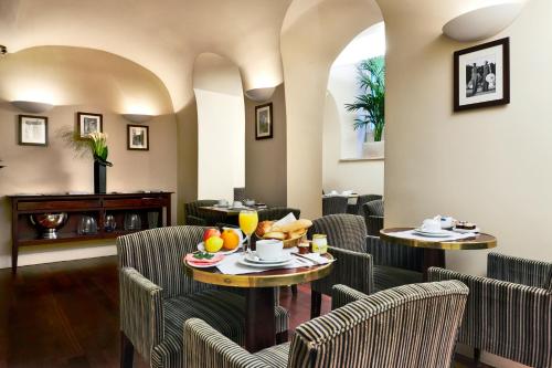 - un restaurant avec des chaises et des tables avec des fruits dans l'établissement Golden Tulip Washington Opera, à Paris