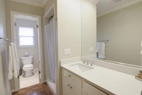 Baño blanco con lavabo y aseo en Tarrytown Townhouse en Austin