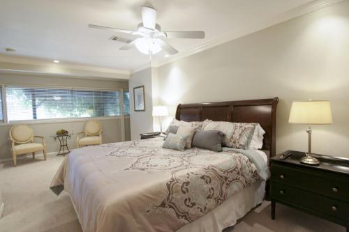 a bedroom with a large bed with a ceiling fan at Tarrytown Townhouse in Austin