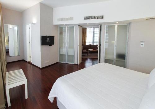 a bedroom with a large white bed and a chair at Hotel Guarani Asuncion in Asuncion