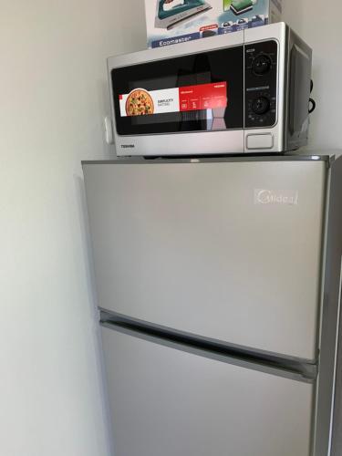 a microwave sitting on top of a refrigerator at Maya New Guest House -Panoramic Sea&CityCentre View, Haifa in Haifa
