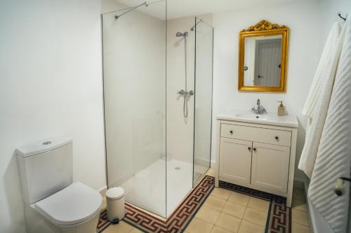 y baño con ducha, aseo y lavamanos. en La Casa del Boticario, en Alcalá del Júcar