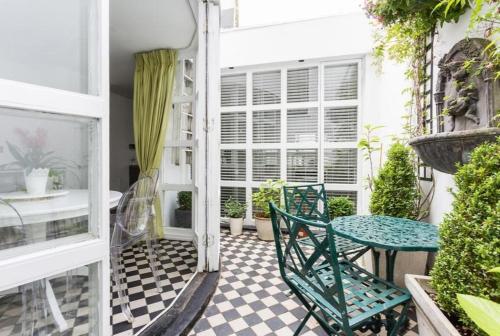 a patio with a table and chairs on a porch at Marylebone Luxury Duplex 3 Bedroom Residence in London