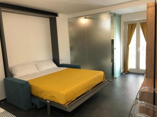a bedroom with a bed with a yellow blanket at Alley House in Cefalù