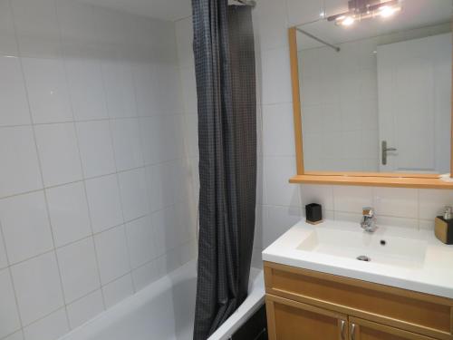 uma casa de banho com um lavatório, uma banheira e um espelho. em Chambre privé entre Lyon et St Etienne em Rive-de-Gier
