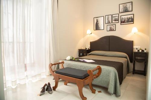 a bedroom with a bed and a chair and a table at Casa Palacio Don Pedro in Seville