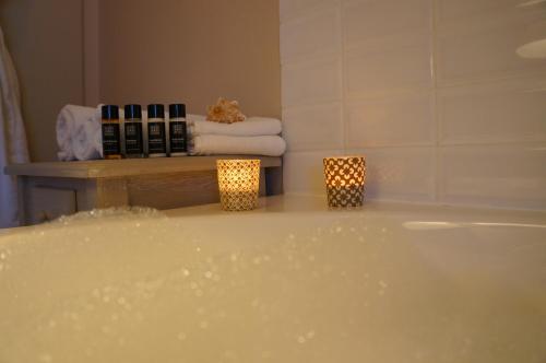 a bathroom with a tub and towels and candles at B&B Oesterhoeve in Ostend