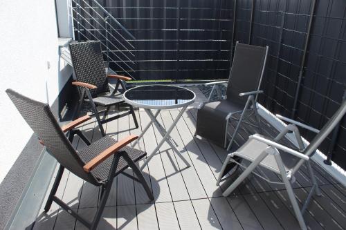eine Terrasse mit Stühlen, einem Tisch und einem Grill in der Unterkunft Köln und Natur in Erftstadt