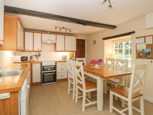 a kitchen with a wooden table and a dining room at Webstone House in Northallerton