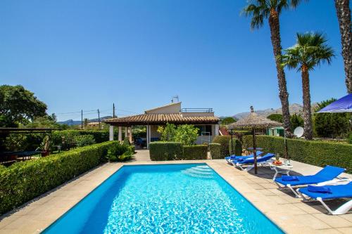 a swimming pool with lounge chairs and a house at Pantina in Pollença