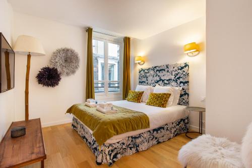 a bedroom with a bed and a window at CMG Champs Elysées- Boetie 4GG in Paris