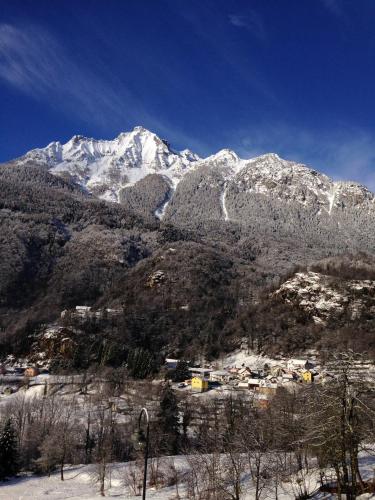 a snow covered mountain with a town in front of it at Affittacamere Ca' Fattorini in Baceno