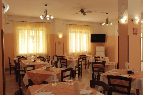 a restaurant with tables and chairs and a ceiling fan at Albergo Il Terrazzino in Vibo Valentia Marina