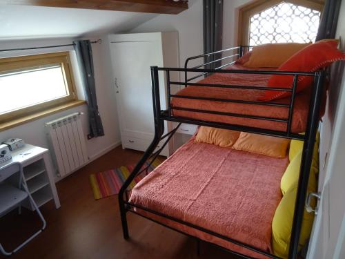 - une chambre avec des lits superposés et un banc dans l'établissement la bottega del fabbro affitto breve, à Contigliano