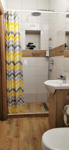 a bathroom with a shower curtain and a sink at Canti apartments in Novi Sad