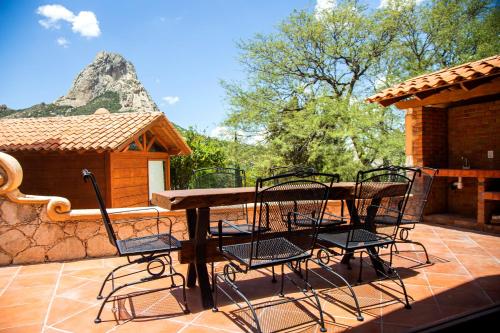 a wooden table and chairs sitting on a patio at Zidada Hotel and Chalets in Bernal