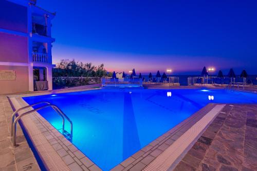 a large blue swimming pool at night at Boletsos Beach in Argasi