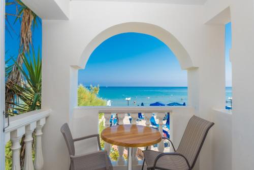 a dining room with a table and chairs and a view of the beach at Boletsos Beach in Argasi