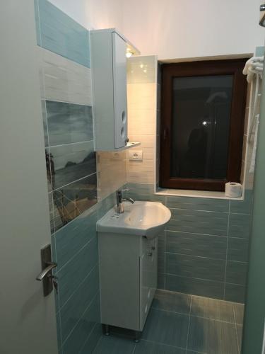 a bathroom with a white sink and a window at Sweet Desire in Vama Veche