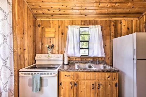 a kitchen with a stove and a sink and a refrigerator at Couples Cabin with Luxury Deck, 1 Mi to Canyon Lake! in Canyon Lake